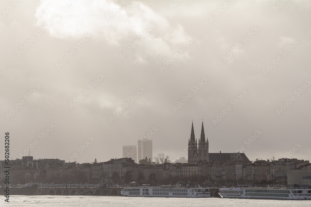 Panorama of the garonne quay (quais de la garonne), in Bordeaux, France, with the Saint Andre Cathedral behind during a winter afternoon sunset. Bordeaux is the main French southwestern city.....
