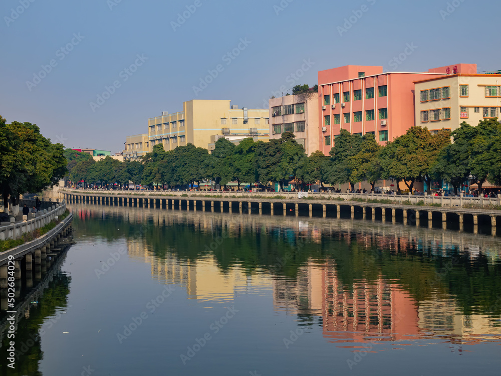 Sunny view of the River, building, trees and reflection