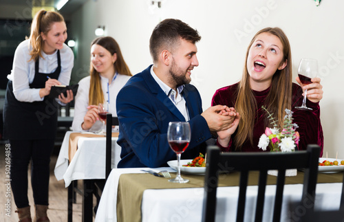 Elegant female and her boyfriend are celebrating date for dinner in luxury restaurante indoor.