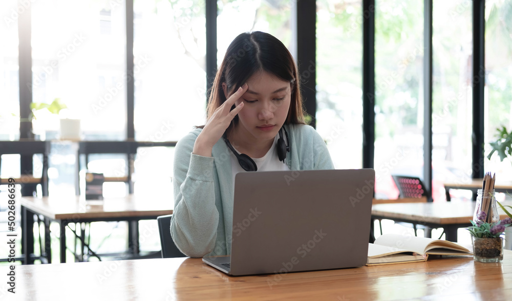 Serious focused Asian student using laptop in kitchen, looking at screen with attention and concentration, watching learning webinar, virtual training, video course, studying from home Serious focused Asian student using laptop in kitchen, looking at screen with attention and concentration, watching learning webinar, virtual training, video course, studying from home