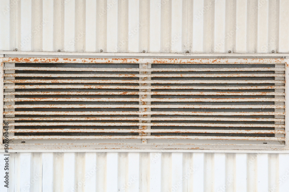 Old, rusty, with peeling paint, ventilation window grille on a sheathing wall, background image, texture Old, rusty, with peeling paint, ventilation window grille on a sheathing wall, background image, texture