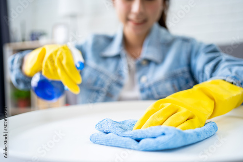 Beautiful young Asian woman cleaning house with microfiber rag. Housekeeping concept.