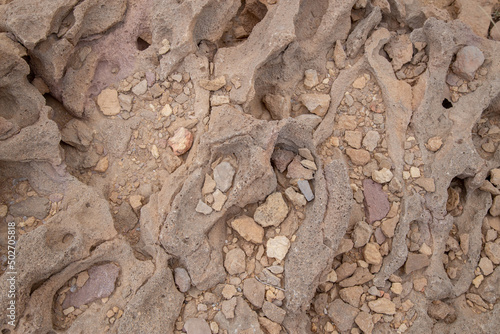 rock formation with sand and lava rock in desert with grain and out of focus up close