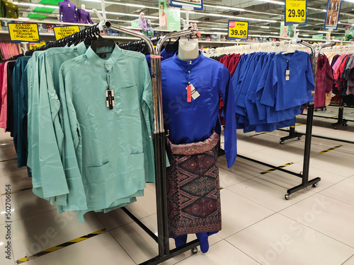 SELANGOR, MALAYSIA - APRIL 30, 2022: Baju Melayu to be worn during the Hari Raya celebration is on display for sale. To be worn by men and boys. Sorted by type and size. Tagged with a price tag. photo
