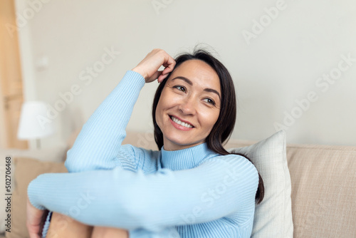 Portrait of smiling middle aged Asian woman looking at camera. Beautiful woman smiling at home.