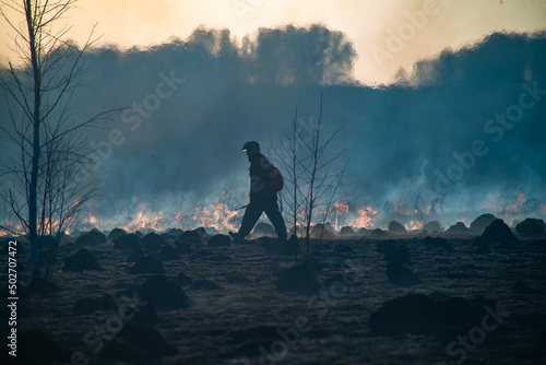 a firefighter walking in burning fields