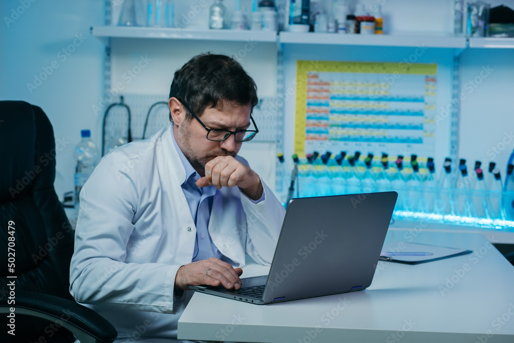 Male scientist working in the laboratory with laptop computer and liquid chemical Male scientist working in the laboratory with laptop computer and liquid chemical