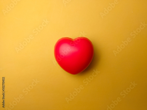 Top view red heart shape on yellow background. Can use for heart check up or love concept