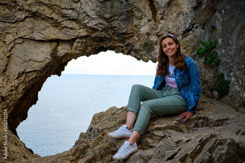 Foto scattata ad una ragazza in posa davanti all'ingresso della famosa Grotta dei Falsari a Noli.