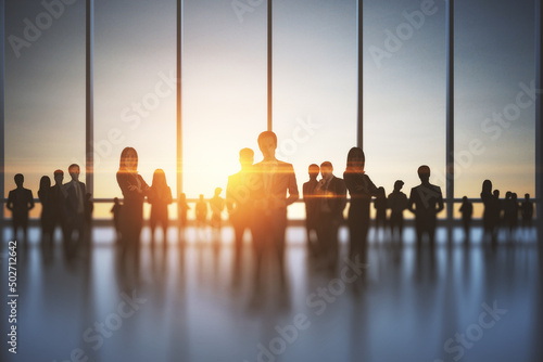 Fotografiet Backlit crowd of businesspeople working together in office interior with sunlight