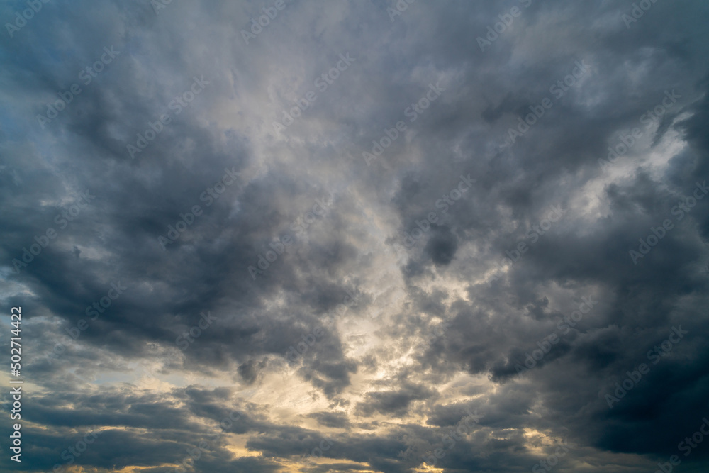 Dark gloomy clouds on a stormy sky. Natural atmospheric background.
