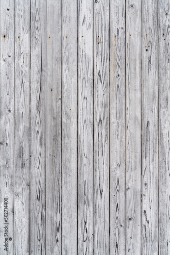 Vintage fence of old wooden boards. Texture of an aging wooden surface. Beautiful wooden background.