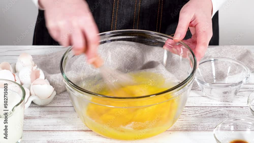 Time lapse. Mixing ingredients in a large glass mixing bowl to prepare French toast. Time lapse. Mixing ingredients in a large glass mixing bowl to prepare French toast.