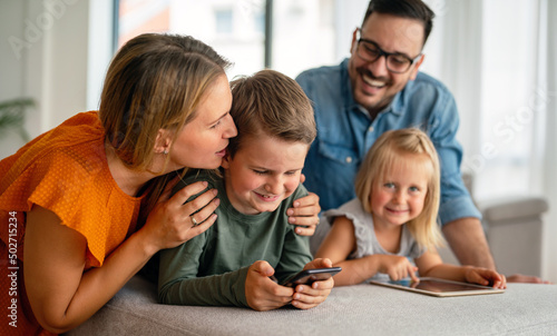 Happy family spending time at home with digital devices together. Technology people fun concept.