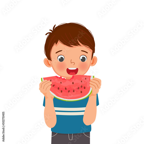 Cute little boy eating watermelon on sunny day in summertime