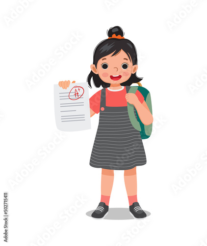 cute little schoolgirl holding exam paper with good mark A plus grade in test result feeling happy