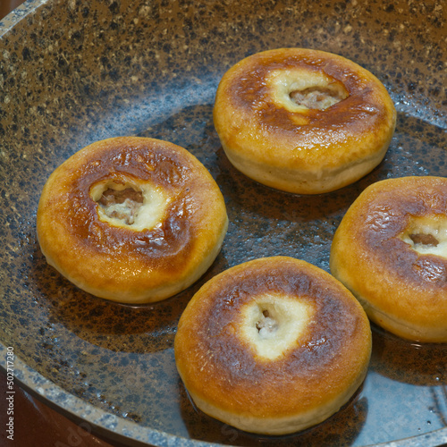 Meat donuts fried in a frying pan. Closeup