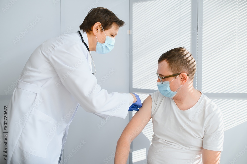 Obraz premium Female doctor vaccinating a man