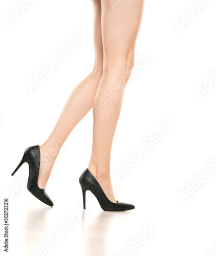 Perfect female legs wearing high heels isolated on white background. Side view