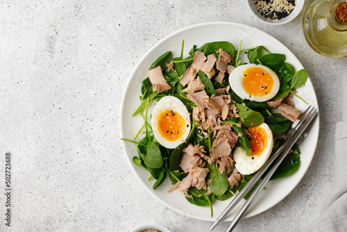 Tuna salad with boiled egg and spinach on white plate. Keto diet, healthy food. Fresh salad bowl. Dinner. Top view, copy space