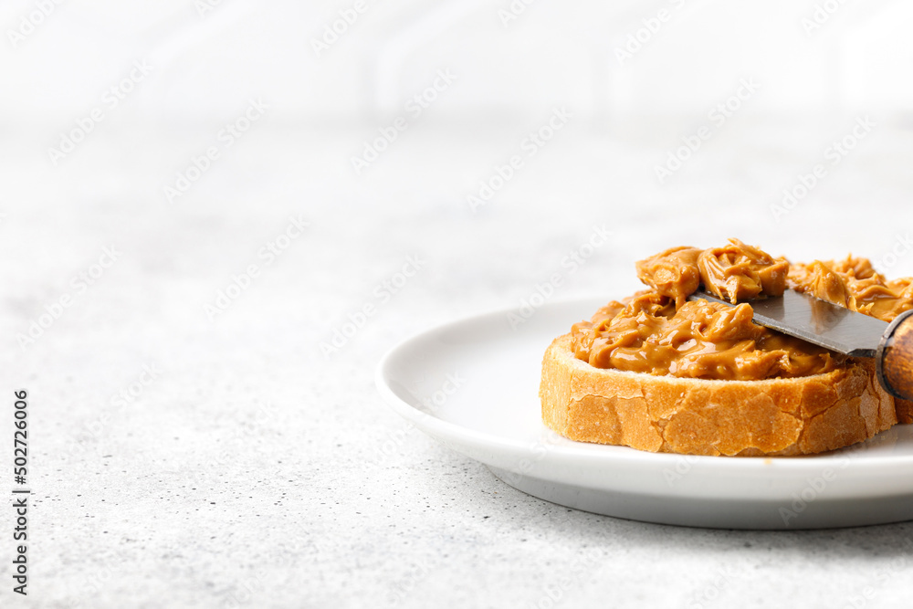 Toast with Peanut butter. Sweet Peanut butter sauce on bread with knife. Texture, Close up. Toast with Peanut butter. Sweet Peanut butter sauce on bread with knife. Texture, Close up.