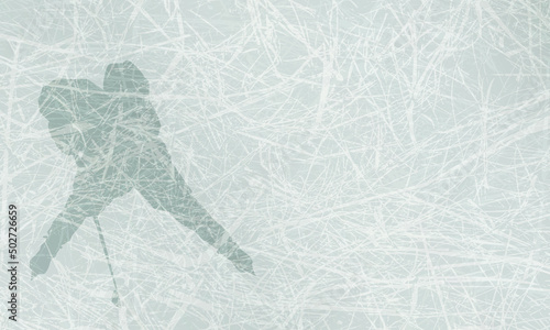 Sports background with silhouette of a young hockey player with a stick. Light blue ice texture with space for text
