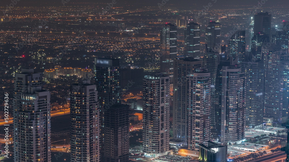 JLT skyscrapers near Sheikh Zayed Road aerial night timelapse. Residential buildings JLT skyscrapers near Sheikh Zayed Road aerial night timelapse. Residential buildings