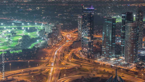JLT skyscrapers with golf course near Sheikh Zayed Road aerial night timelapse. Residential buildings