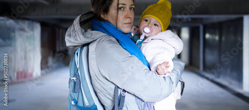 Devoted mother carrying her small child in the bomb shelter