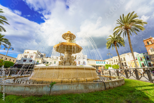 Mérida, Spain. April 28, 2022. View of the Spain Square. The square shows a neo-baroque marble fountain from the end of the 19th century, made at the workshop of Germano José do Salles