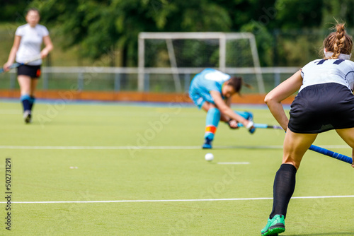 Young woman field hockey player in defense position on the game. © skumer