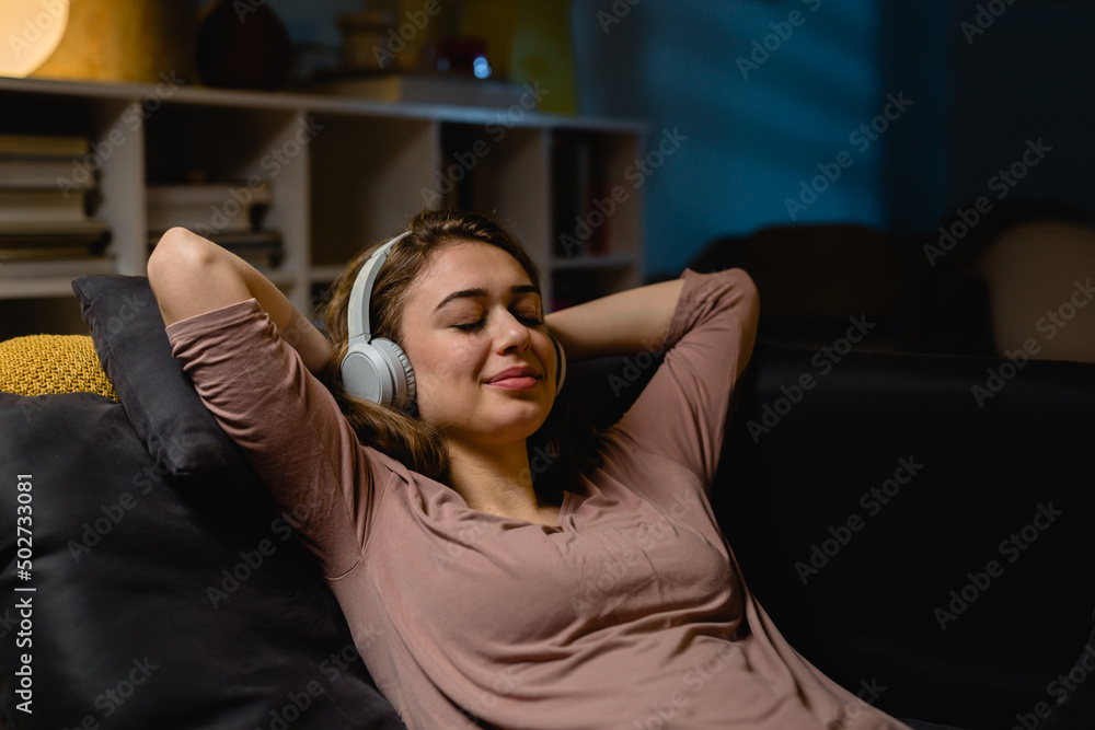 Obraz premium woman relaxing on sofa and listening music