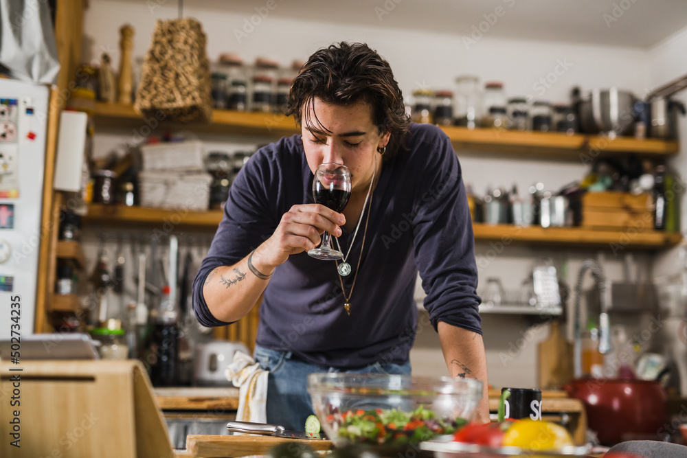 man tasting wine in kitchen