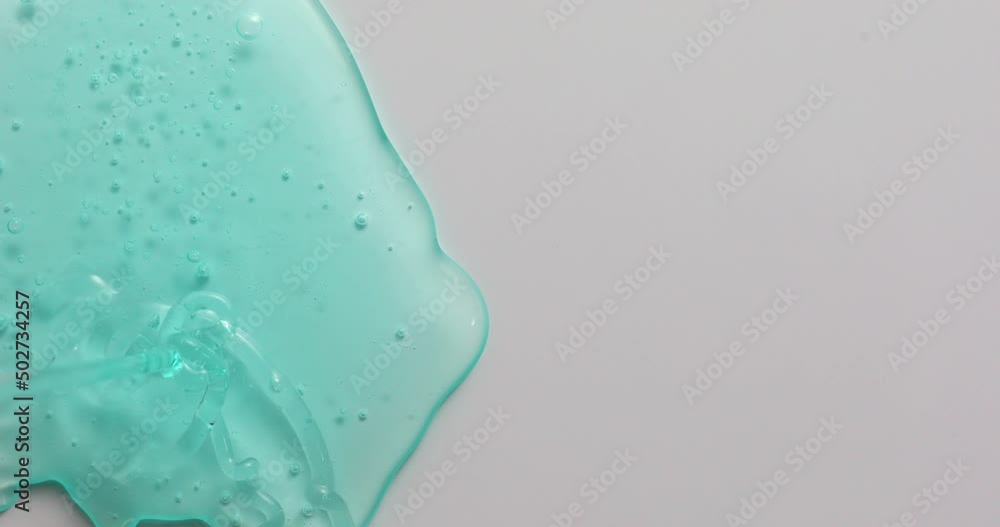 Blue cream liquid gel serum flowing down on grey texture, makeup and cosmetics background, skincare or hair product Blue cream liquid gel serum flowing down on grey texture, makeup and cosmetics background, skincare or hair product