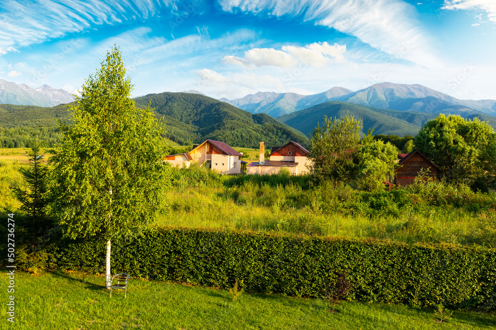 summer vacations in rural area of romania. beautiful landscape with carpathian fagaras ridge in the distance. nature scenery with fluffy clouds on the sky in evening light summer vacations in rural area of romania. beautiful landscape with carpathian fagaras ridge in the distance. nature scenery with fluffy clouds on the sky in evening light