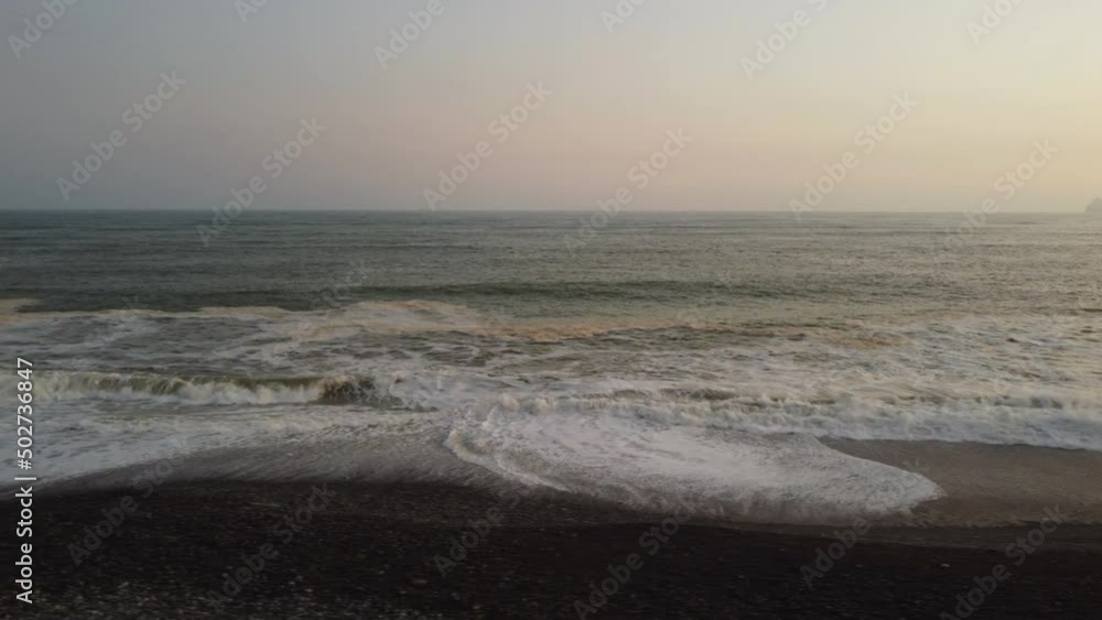 Drone video of rocky beach ocean shore, in Lima, Peru. Minutes after sunset so sky is a little orange. The shot was recorded flying to the left while keeping focus on the horizon straight ahead. Drone video of rocky beach ocean shore, in Lima, Peru. Minutes after sunset so sky is a little orange. The shot was recorded flying to the left while keeping focus on the horizon straight ahead.
