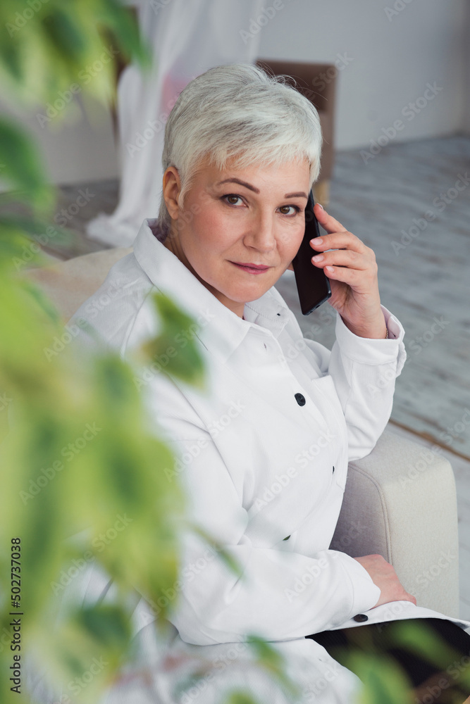 Senior business woman or freelancer talking by smartphone indoors Senior business woman or freelancer talking by smartphone indoors