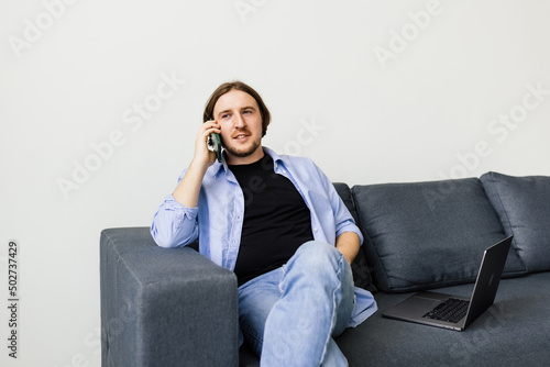 Portrait of a young man using a mobile phone on couch