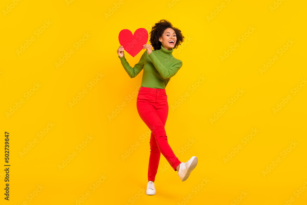 Full size photo of young lovely lady have fun hold paper heart postcard gift romance isolated over yellow color background