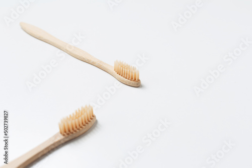 Close-up of two bamboo toothbrushes on white background.