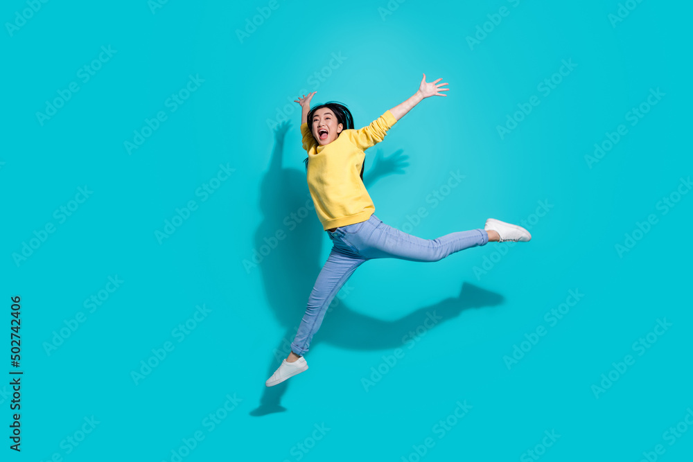 Full length photo of pretty sweet lady dressed yellow sweater jumping dancing empty space isolated turquoise color background