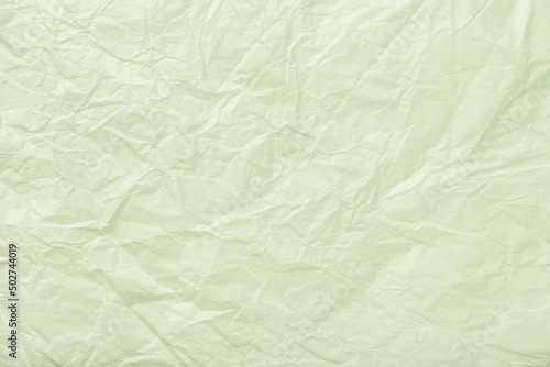 Texture of crumpled pastel green wrapping paper, closeup. Olive abstract background.
