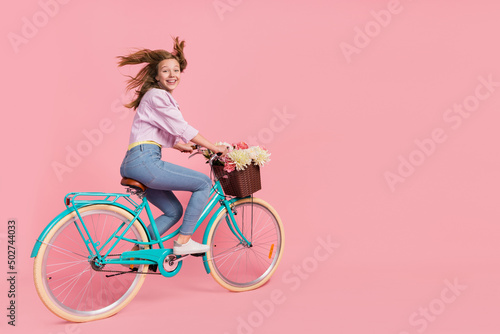 Photo of funky courier lady person drive bike wind blow hair wear casual outfit isolated pink color background © deagreez