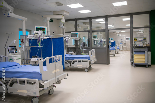 Empty Modern technology in intensive care unit room with different equipment and devices, beds and pillows.