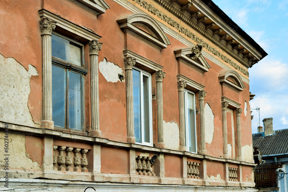 fragment of a row of windows with gables and cornice on the facade of an old house in the historic city