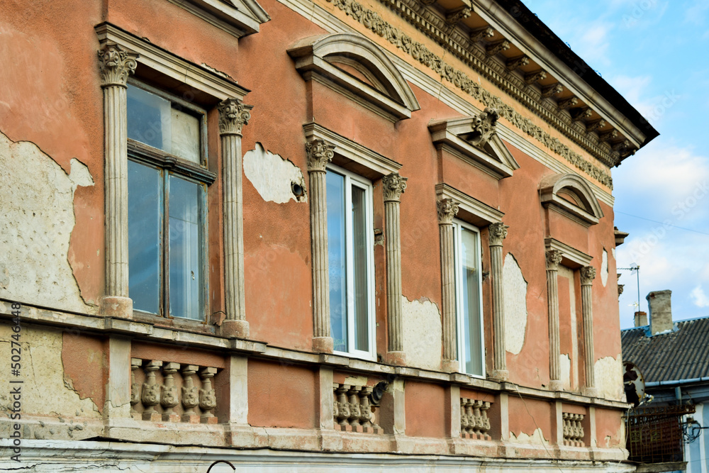 Naklejka premium fragment of a row of windows with gables and cornice on the facade of an old house in the historic city
