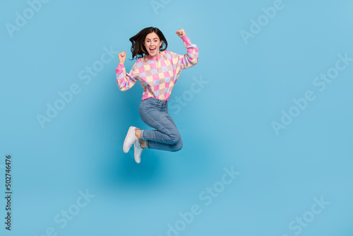 Full length photo of young excited lady jump up rejoice triumph ecstatic lottery fists hands isolated over blue color background
