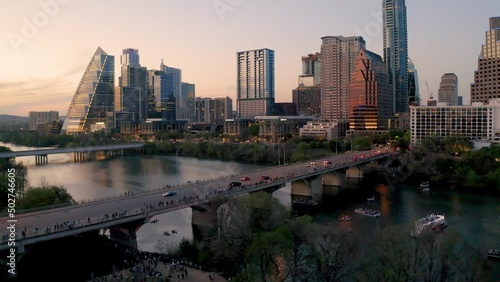 Downtown Austin Texas skyline in summer 2022, buildings reflecting sunset at golden hour aerial drone over South Congress bridge and Town Lake as tourists await bats photo