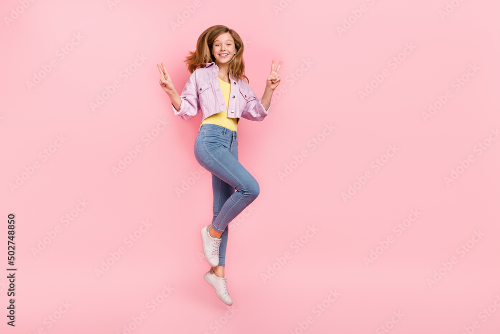 Photo of friendly confident positive lady jump show v-sign wear casual jacket isolated pink color background Photo of friendly confident positive lady jump show v-sign wear casual jacket isolated pink color background