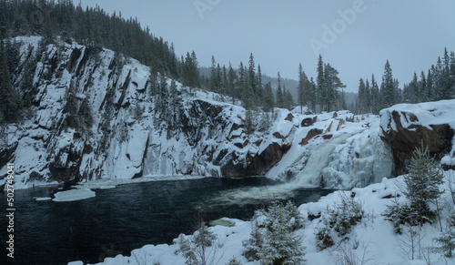 Freezing watrfall in winter snowy scenery photo